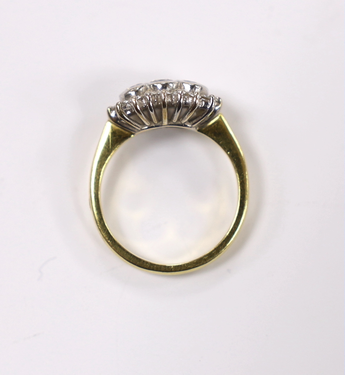 A modern 18ct gold and collet set three stone diamond ring, with diamond chip set border, size J/K, gross weight 4.6 grams.